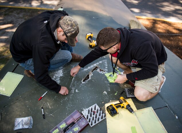 Airman 1st Class Matthew Hoofnagle, 437th Maintenance Squadron sheet metal technician and Senior Airman John Yesis, 437th MXS sheet metal technician, make repairs to an F-4 Phantom II Oct. 18, 2015, on the parade grounds at the Citadel in Charleston, S.C. During the recent storms that impacted the east coast, trees damaged the static aircraft. Parts of the wing, underwing and fuselage were severely compromised. The 437th AMXS volunteered weekends to assist the Citadel in repairing the aircraft. (U.S. Air Force photo/Airman 1st Class Clayton Cupit)