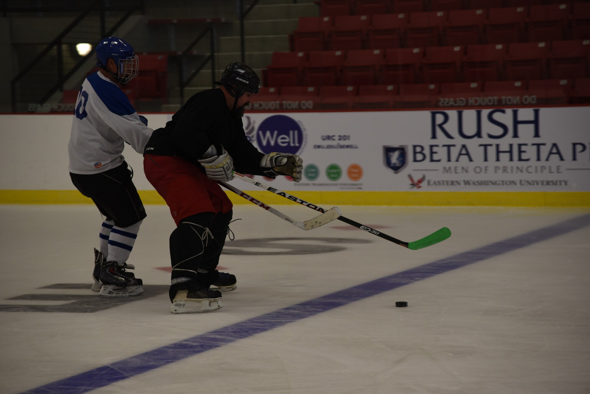 Master Sgt. Richard Ortega, Fairchild Falcons vice president and Mr. Kenny Jones, with Eastern Washington University, compete for the puck during a scrimmage Sept. 30, 2015, at Eastern Washington University, Wash. The Falcons were formed in 2013 and have been evolving ever since. By using resources the base offers the Falcons were able to grow by spreading word to Airmen through programs like Right Start. (U.S. Air Force photo/Airman 1st Class Sean Campbell)