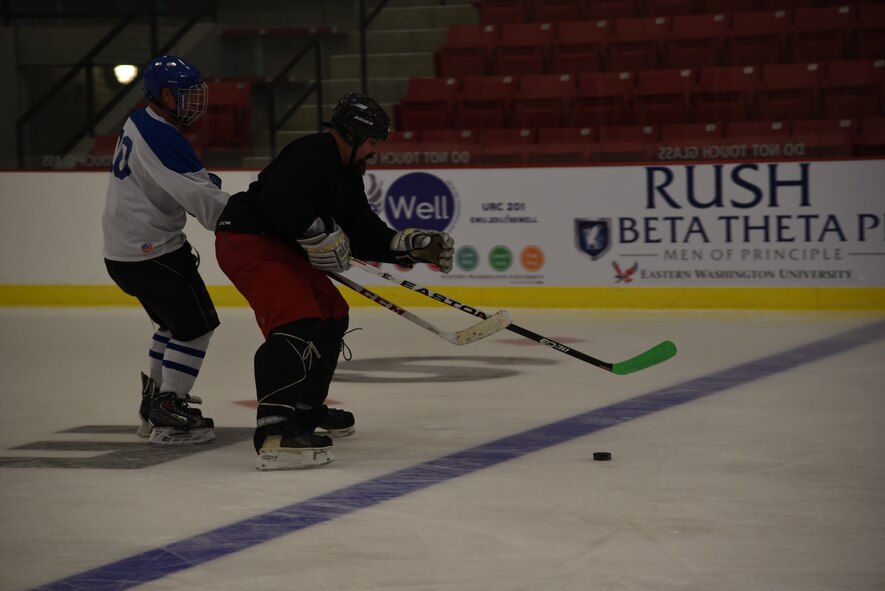 Master Sgt. Richard Ortega, Fairchild Falcons vice president and Mr. Kenny Jones, with Eastern Washington University, compete for the puck during a scrimmage Sept. 30, 2015, at Eastern Washington University, Wash. The Falcons were formed in 2013 and have been evolving ever since. By using resources the base offers the Falcons were able to grow by spreading word to Airmen through programs like Right Start. (U.S. Air Force photo/Airman 1st Class Sean Campbell)
