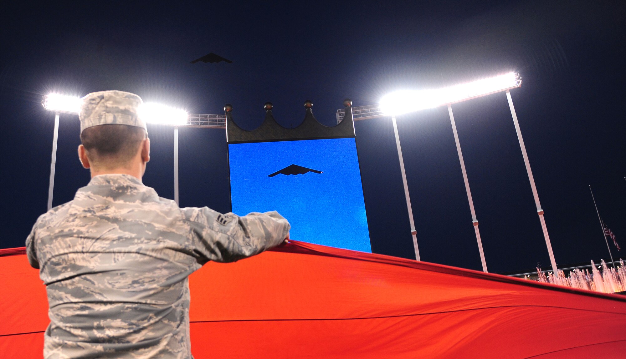 A B-2 Spirit flies over Kauffman Stadium in Kansas City, Mo., during the playing of the National Anthem at the American League Championship Series Oct. 16, 2015. Over 100 service members from Whiteman Air Force Base, Mo., participated in a pregame flag ceremony. (U.S. Air Force photo by Senior Airman Joel Pfiester/Released)