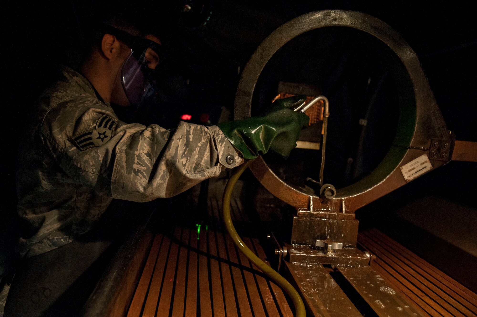 Senior Airman Michael Vigil, 19th Maintenance Squadron Non-Destructive Inspection journeyman, runs an aircraft part under a chemical bath Oct. 14, 2015, on Little Rock Air Force Base, Ark. NDI Airmen find tiny faults in aircraft parts by running them through multiple chemical baths. (U.S. Air Force photo by Airman 1st Class Mercedes Muro) 