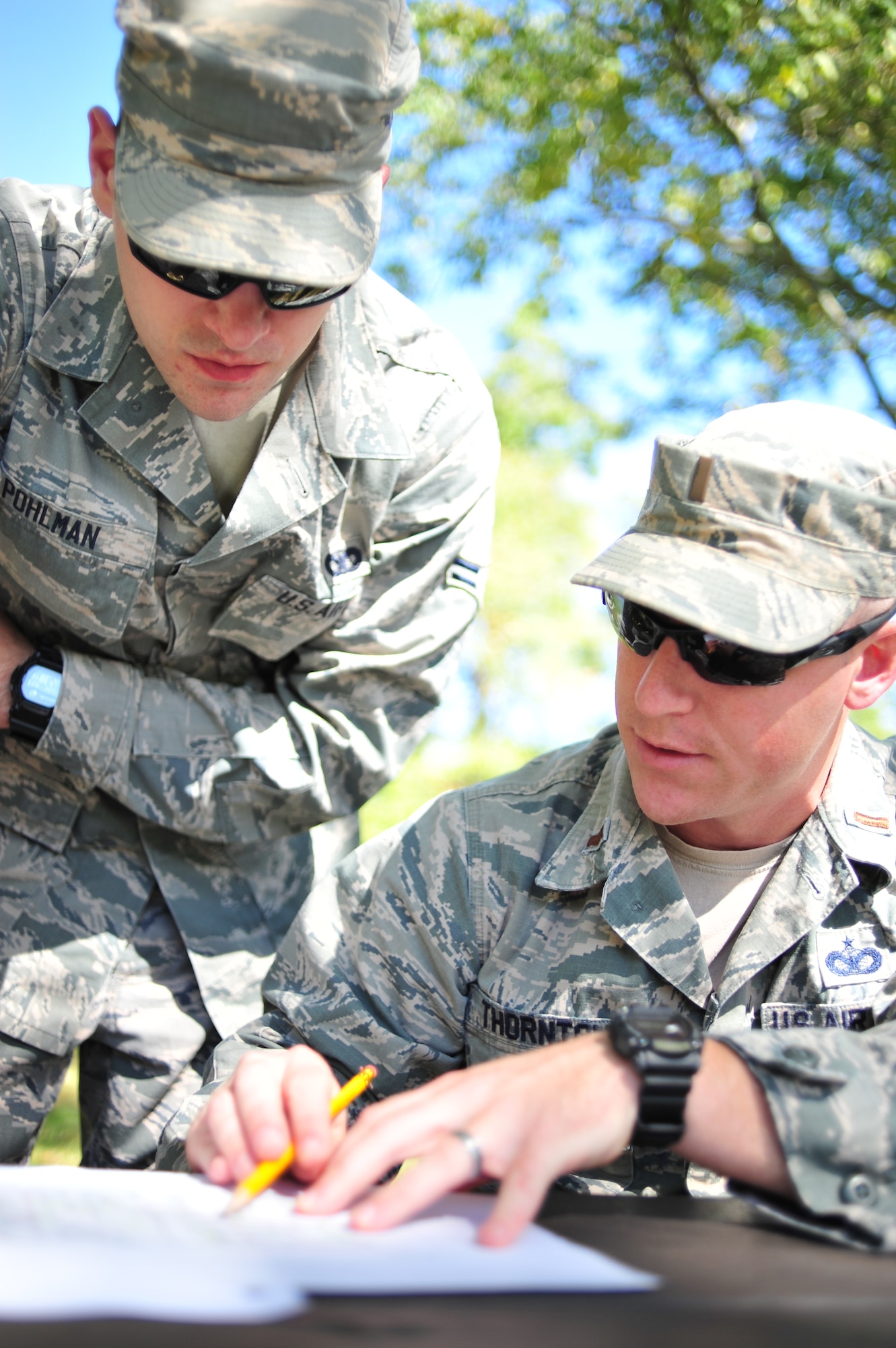 Ohio Air National Guard 2nd Lt. Sam Thornton, security forces operations officer with the 180th Fighter Wing, reviews the instructions and map for a land navigation course with a fellow Airman at Oak Openings Metro Park in Swanton, Ohio, on Sep. 27, 2015. The 180th Security Forces Squadron performed their annual training requirement by plotting location points on maps and using compasses to find their way through the park. (Ohio Air National Guard photo by Staff Sgt. John Wilkes)