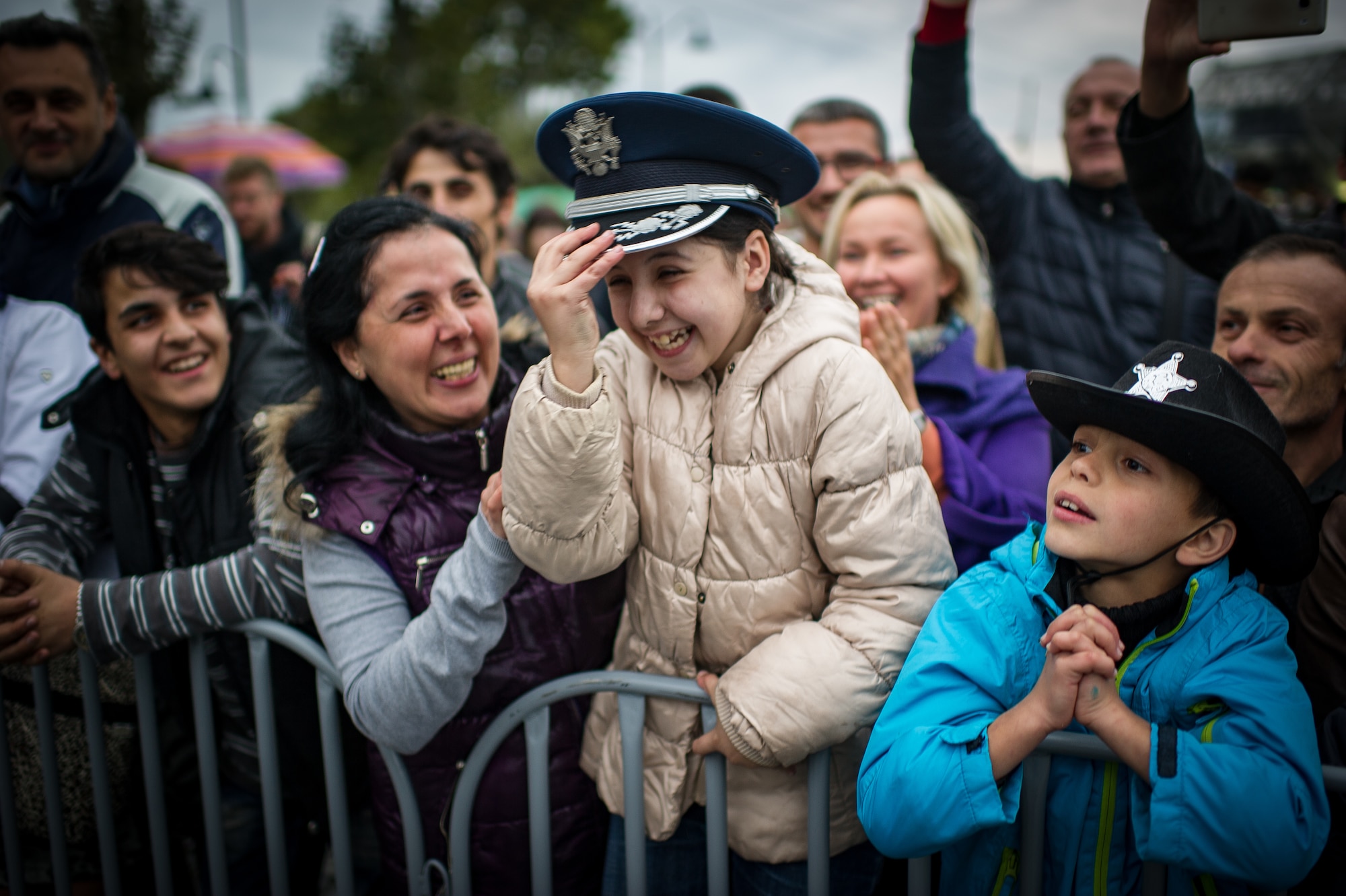 A Georgian girl laughs while wearing a U.S. Air Forces in Europe Band member's hat during a marching band show in Tbilisi, Georgia, Oct. 17, 2015. From Oct. 15-19, 33 bandsmen from the U.S. Air Forces in Europe Band traveled to the Republic of Georgia for several events including performing in the First International Military Bands Festival in Tbilisi. This is the first time in nearly 10 years that the USAFE Band has traveled to conduct a mission in the Republic of Georgia. Georgia and the U.S. are proven military partners and engagements like these help to further strengthen the bonds between our two nations. (U.S. Air Force photo/ Tech. Sgt. Ryan Crane)