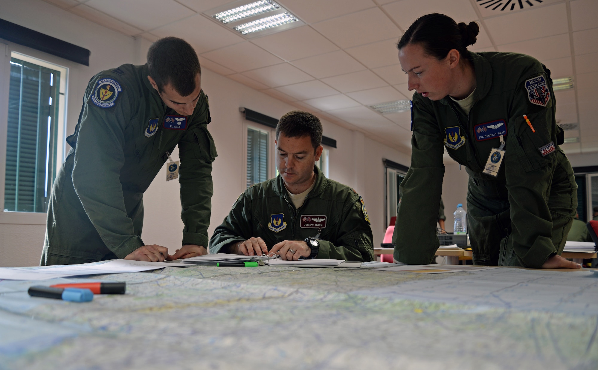 From left to right, U.S. Air Force Capt. RJ Allen, 351st Air Refueling Squadron pilot, U.S. Air Force Maj. Joseph Smith, 351st ARS instructor pilot, and U.S. Air Force Senior Airman Danielle Repp, 351st ARS boom operator, study and plan for an air refueling mission Oct. 21, 2015, at Son San Juan Air Base, Spain. Exercise Trident Juncture aims to train NATO Response Force Allies and other Allied forces. The Airmen from the 351st Air Refueling Squadron will refuel approximately 130 aircraft during the course of the exercise. (U.S. Air Force photo by Senior Airman Christine Halan/Released)
