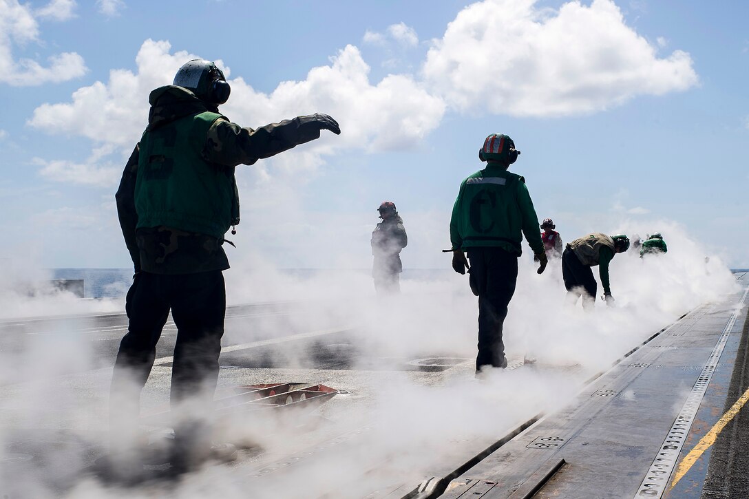 U.S. sailors wrap a catapult on the flight deck of the aircraft carrier USS George Washington in the Pacific Ocean, Oct. 19, 2015. U.S. Navy photo by Petty Officer 3rd Class Bryan Mai