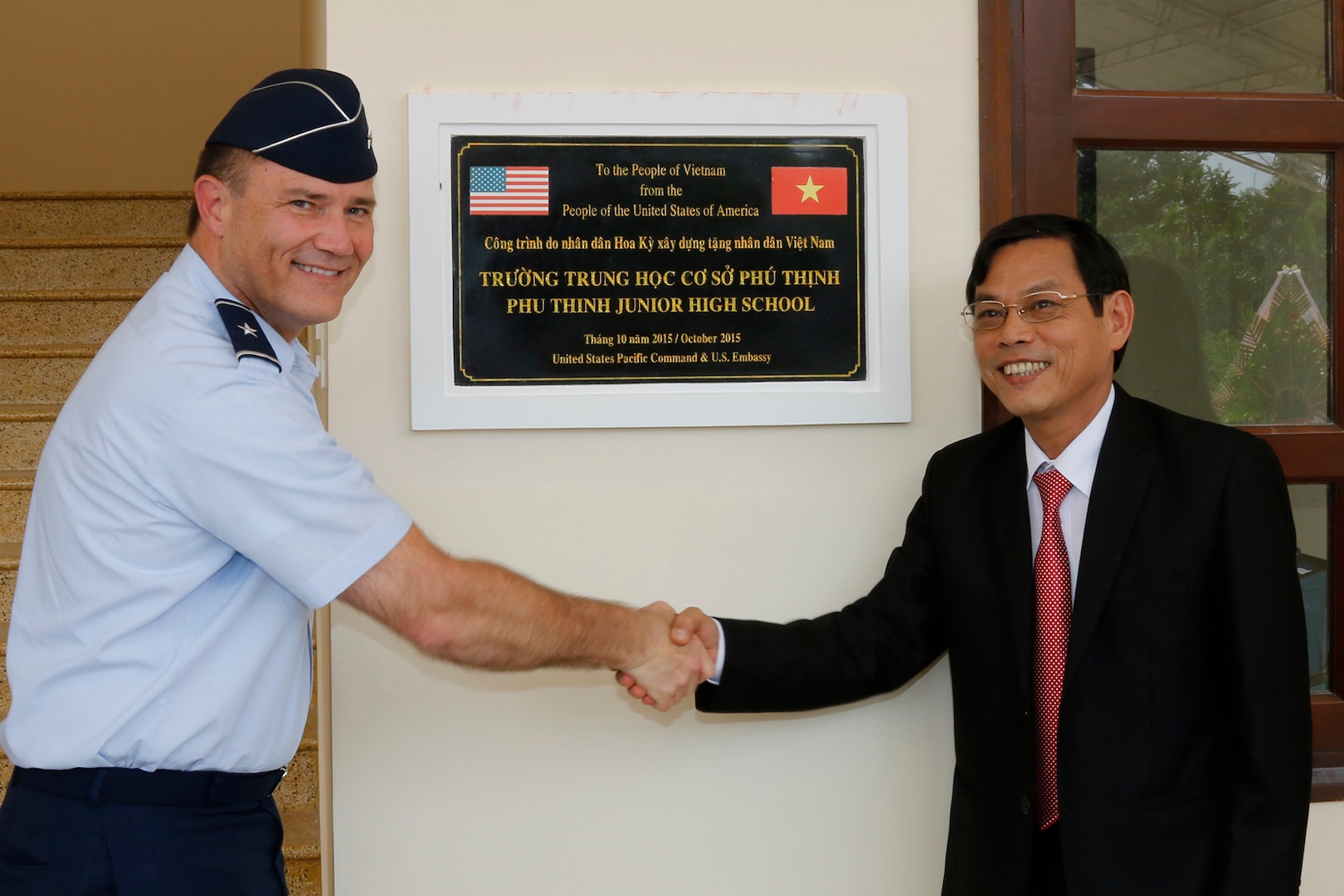 Brig. Gen. Michael E. Stencel, adjutant general, Oregon, and Nguyen Chin, Deputy Chairman of the Quang Nam Provincial People's Committee, unveil a plaque memorializing U.S. and Vietnamese cooperation in building a new intermediate school in Phu Tinh Village in the Quang Nam Province of Vietnam, Oct. 21, 2015. The new school was built in cooperation between the U.S. and Vietnam and has a secondary use as a shelter during natural disasters. 