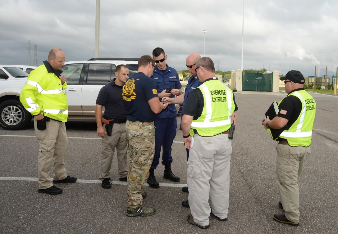 Bomb squad technician and law enforcement officer look on as a U.S. Coast Guard team outlines a floor lay-out and identifies a safe entry point into a building after the team’s K-9 Unit alerts the detection of a bomb at the location. The drill was conducted during a full-scale exercise at Marine Corps Support Facility Blount Island, Jacksonville, Fla., recently. Exercise controllers/evaluators monitor the mutual aid partners’ verbal exchange, responses and plan of action for handling the potential threat.
