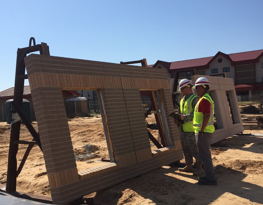 1st Lt. Thomas Zarack (left) of the Technical Engineer Competency Development Program and Romeo Enriquez (right), a Mechanical Engineer in the Construction Division, perform a quality assurance inspection on a concrete panel soon to be placed on the 600-room Advanced Individual Training Phase II Barracks at Fort Gordon Oct. 16.