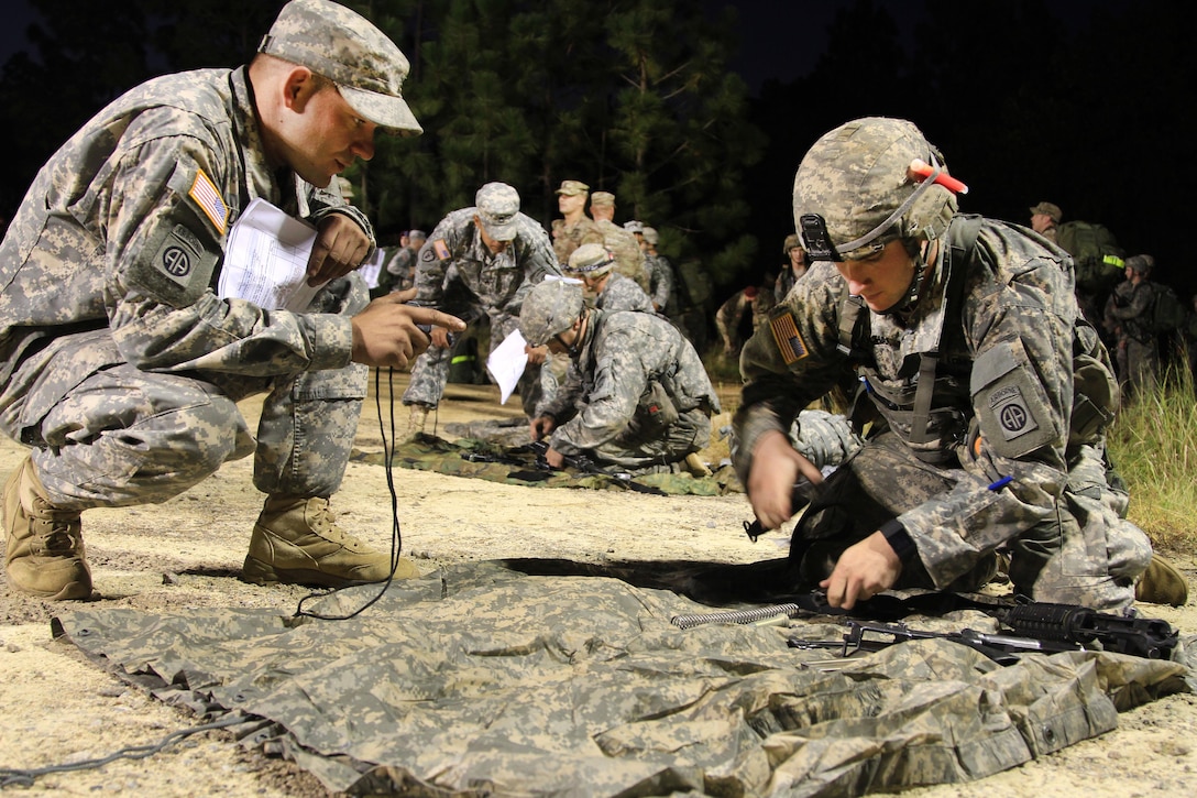 A paratrooper disassembles and reassembles an M4 carbine rifle after completing a 12-mile tactical foot march during Expert Infantryman Badge testing on Fort Bragg, N.C., Oct. 16, 2015. U.S. Army photo by Staff Sgt. Jason Hull