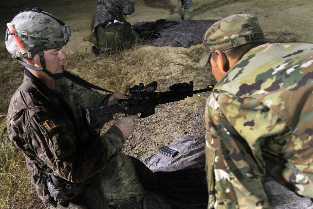 Army Sgt. Jordan Wenstrom, left, performs a function check on an M4 carbine rifle after completing a 12-mile tactical foot march during Expert Infantryman Badge testing on Fort Bragg, N.C., Oct. 16, 2015. Wenstrom is an infantryman assigned to the 82nd Airborne Division's 2nd Battalion, 508th Parachute Infantry Regiment, 2nd Brigade Combat Team. U.S. Army photo by Staff Sgt. Jason Hull