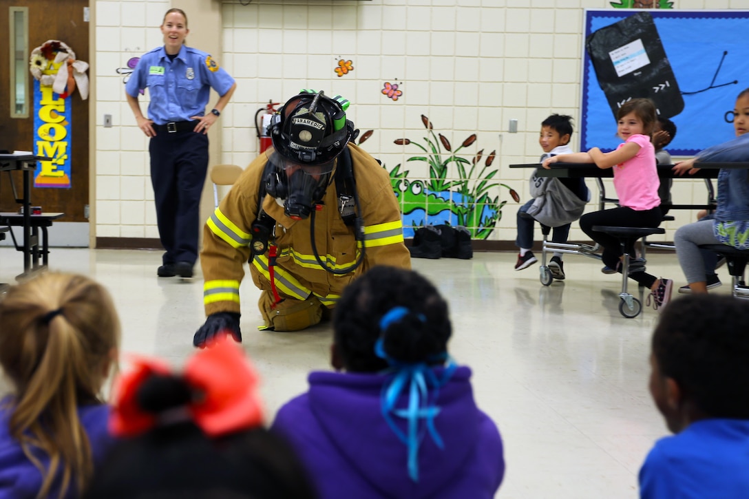 Robert Harrell demonstrates a firefighter’s safety equipment during a visit to W. J. Gurganus Elementary School in Havelock, N.C., Oct. 22, 2015. Members of the Marine Corps Air Station Cherry Point Fire and Emergency Services Department visited the local elementary school to teach children about the importance of fire safety and prevention. The air station fire department actively participates in school visits to encourage children of all ages to practice safety measures to keep both their families and themselves safe. Harrell is a firefighting paramedic with the MCAS Cherry Point Fire and Emergency Services Department. (U.S. Marine Corps photo by Cpl. N.W. Huertas/Released)