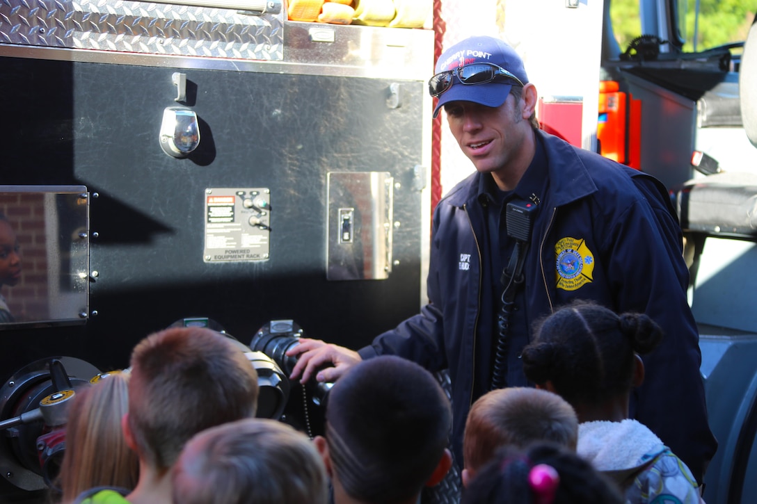 Capt. Eddie Hudson showcases some of the functions of a firetruck during a visit to W. J. Gurganus Elementary School in Havelock, N.C., Oct. 22, 2015. Members of the Marine Corps Air Station Cherry Point Fire and Emergency Services Department visited the local elementary school to teach children about the importance of fire safety and prevention. The air station fire department actively participates in school visits to encourage children of all ages to practice safety measures to keep both their families and themselves safe. Hudson is a fire captain with the Cherry Point Fire and Emergency Services Department. (U.S. Marine Corps photo by Cpl. N.W. Huertas/Released)