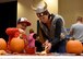 ALTUS AIR FORCE BASE, Okla. – Kathy Hohn, helps a child carve a pumpkin during a deployed family dinner at the Freedom Community Center, Oct. 22, 2015. The dinner is held quarterly for family members of deployed Airmen. There were various activities for children to participate in such as corn hole, fishing, pumpkin carving and rubber duck racing. (U.S. Air Force photo by Senior Airman Franklin R. Ramos/Released