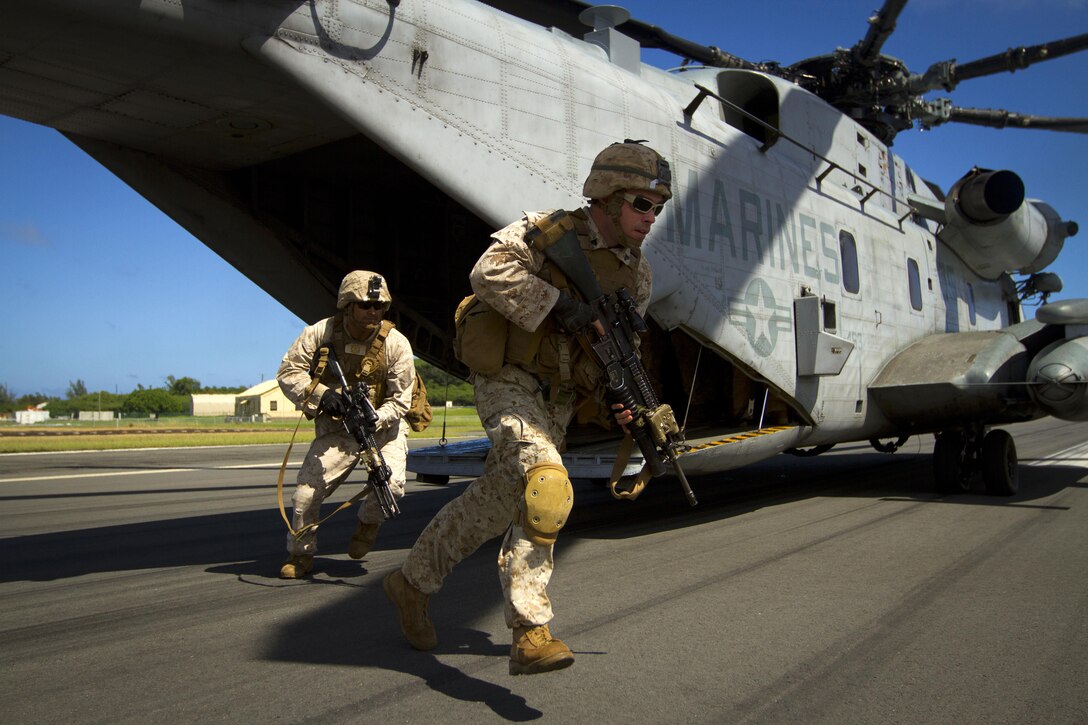 Marines disembark from a CH-53E Super Stallion helicopter as part of an Air-Ground Task Force demonstration at the Kaneohe Bay Air Show on Marine Corps Air Station Kaneohe Bay in Hawaii, Oct. 18, 2015. U.S. Marine Corps photo by Lance Cpl. Aaron S. Patterson  