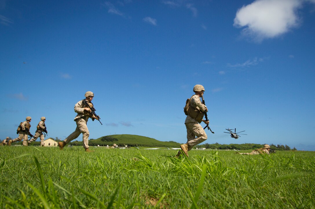 Marines sprint across a field during an Air-Ground Task Force demonstration at the Kaneohe Bay Air Show on Marine Corps Air Station Kaneohe Bay in Hawaii, Oct. 18, 2015. U.S. Marine Corps photo by Lance Cpl. Aaron S. Patterson   