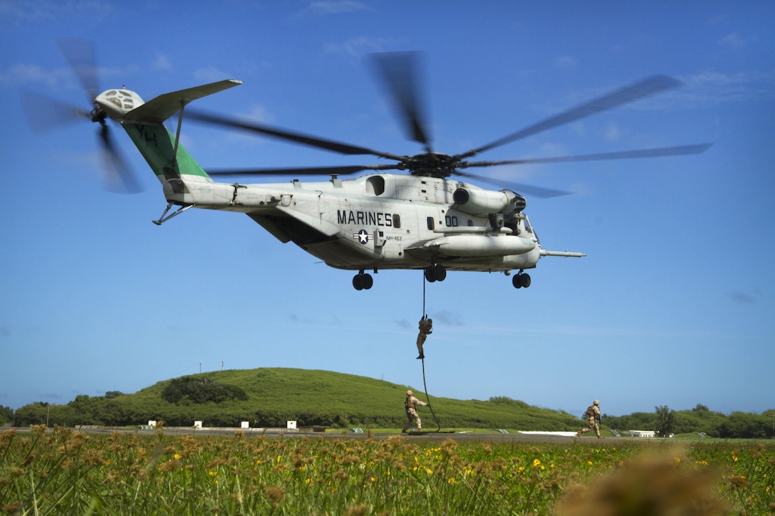 Marines fast-rope from a CH-53E Super Stallion helicopter as part of an Air-Ground Task Force demonstration during the Kaneohe Bay Air Show on Marine Corps Air Station Kaneohe Bay in Hawaii, Oct. 18, 2015. U.S. Marine Corps photo by Lance Cpl. Aaron S. Patterson 