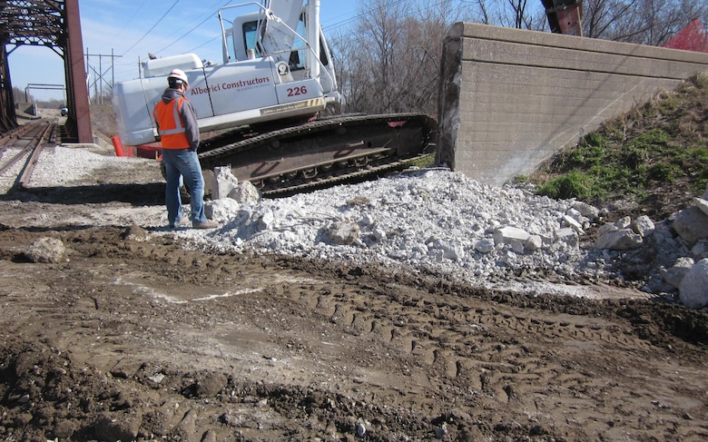 An engineer with the St. Louis District U.S. Army Corps of Engineers looks on during excavation at a portion of floodwall along the Wood River Levee.