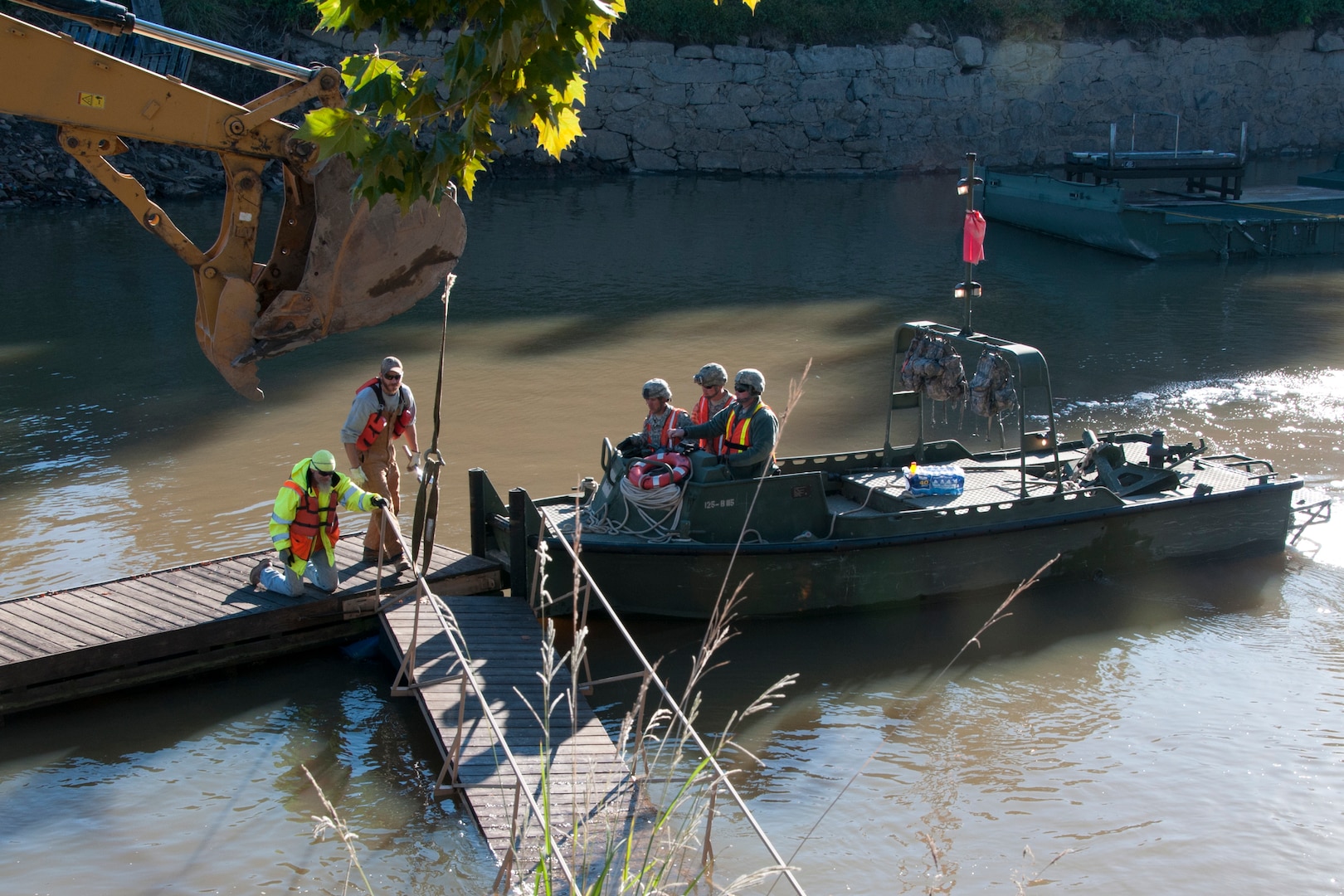 Engineers from the 125th Multi-Role Bridge Company, South Carolina Army National Guard help contractors clear debris out of the canal in Columbia, on Oct. 21, 2015. 