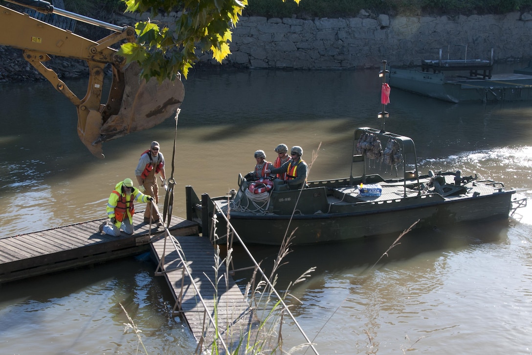 South Carolina Army National Guardsmen operate a watercraft boat to help local contractors remove a heavy steel plate out of the canal in Columbia S.C., Oct. 21 2015, after historic statewide flooding in early October. South Carolina Army National Guard Photo by 2nd Lt. Tracci Dorgan