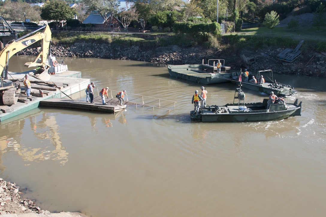 South Carolina Army National Guardsmen operate watercraft boats to help local contractors remove a small metal bridge out of the canal in Columbia S.C., Oct. 21 2015, after historic statewide flooding in early October. 