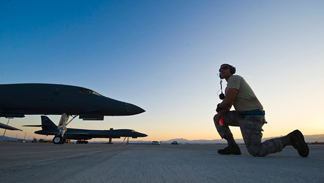 Senior Airman Ellery Lopez, 7th Aircraft Maintenance Squadron crew chief, waits to signal out a B-1B Lancer assigned to the 7th Bomb Wing, Dyess Air Force Base, Texas during Green Flag 14-6 April 24, 2014, at Nellis Air Force Base, Nev. The Green Flag exercise provides aircrew and maintainers training simulating warfare conditions. (U.S. Air Force photo by Senior Airman Christopher Tam)