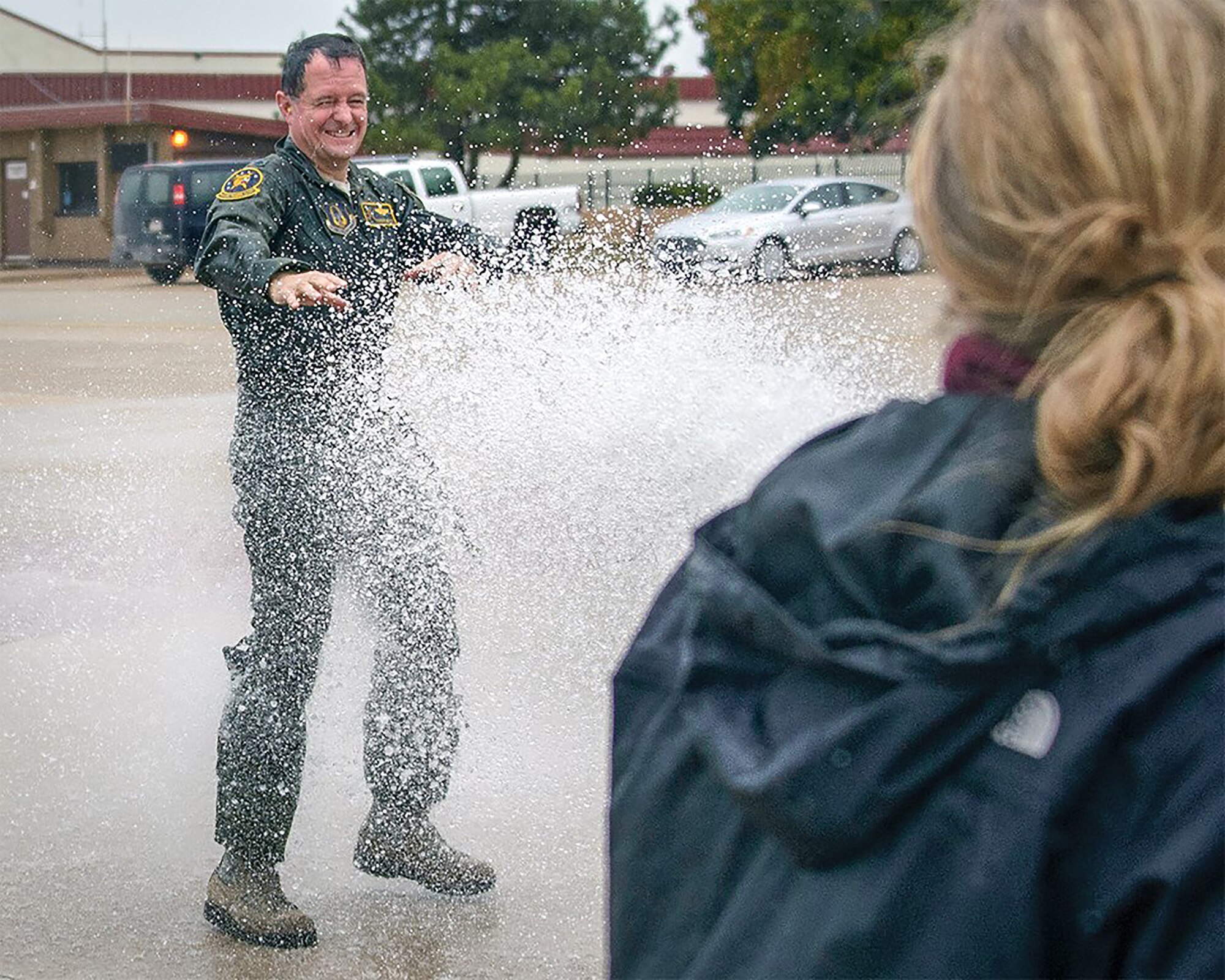 Lt Col. Darren "Shead" McTee gets the traditional fini-flight hose-down from his family following his final flight with the 5th Flying Training Squadron at Vance Air Force Base, Okla. (Courtesy photo)