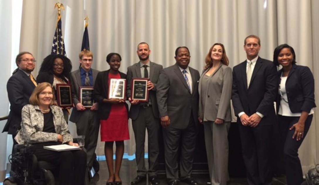 Four Defense Department Workforce Recruitment Program participants received the Judith C. Gilliom Award in recognition of their significant contributions to their organizations, July 28, 2015. From left, Jennifer Sheehy, seated, acting assistant secretary of labor for disability employment policy; Patrick Cokley, Workforce Recruitment Program director in DoL’s Office of Disability Employment Policy; award recipients Divya Hazel, Bryan Richardson, Ericka Hiler and Flynn Rosko; Clarence Johnson, director of DoD's Office of Diversity Management and Equal Opportunity; Stephanie Barna, DoD principal deputy assistant secretary of defense for readiness and force management; Randy Cooper, ODMEO’s disability programs director; and Madison DeGruy, the event’s keynote speaker. DoD photo