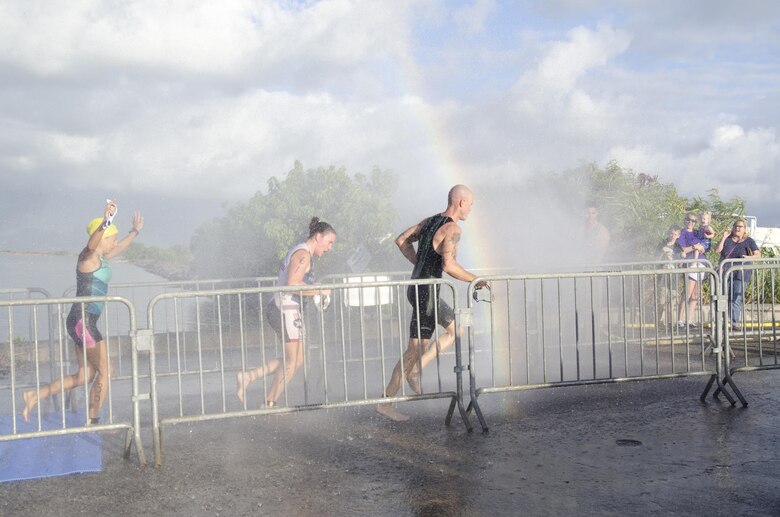 Race participants Elizabeth Mina, Amie Welden and Patrick Fay run through a stream of water to rinse off after finishing the swimming portion of the 12th annual Splash & Dash Biathlon aboard Marine Corps Base Hawaii, Oct. 3, 2015. A joint effort by Marine Corps Community Services Hawaii and Helicopter Maritime Strike Squadron 37, the biathlon was the second to last race in the 2015 Commanding Officer’s Fitness Series. A portion of the net profits went to the squadron’s unit fund. Part of MCCS Hawaii’s mission is to contribute to the retention of Marines, Sailors and family members aboard MCB Hawaii by offering fitness programs and races such as the Splash & Dash Biathlon in garrison and deployed environments. (U.S. Marine Corps photo by Kristen Wong)   