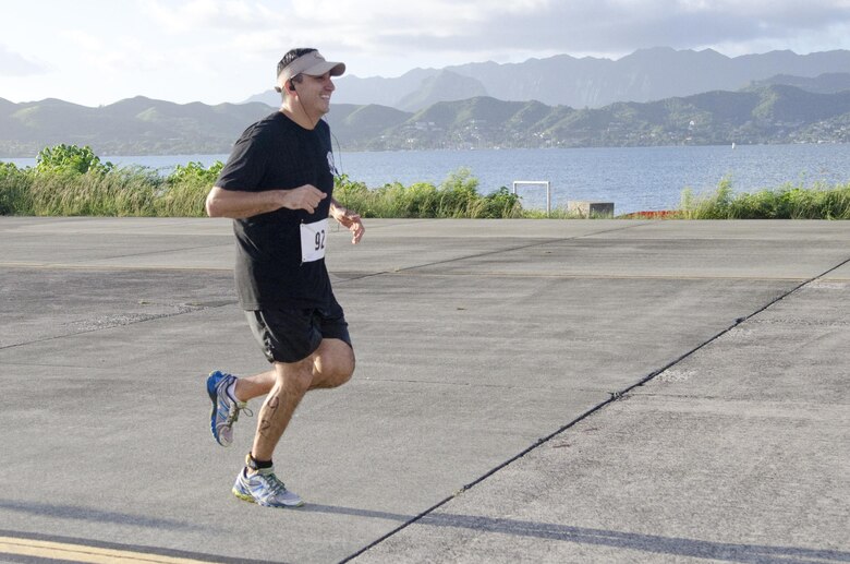 Cmdr. Tony Chavez, the commanding officer of Helicopter Maritime Strike Squadron 37, heads down the flightline during the 12th annual Splash & Dash Biathlon aboard Marine Corps Base Hawaii, Oct. 3, 2015. A joint effort by Marine Corps Community Services Hawaii and Helicopter Maritime Strike Squadron 37, the biathlon was the second to last race in the 2015 Commanding Officer’s Fitness Series. A portion of the net profits went to the squadron’s unit fund. Part of MCCS Hawaii’s mission is to contribute to the retention of Marines, Sailors and family members aboard MCB Hawaii by offering fitness programs and races such as the Splash & Dash Biathlon in garrison and deployed environments. (U.S. Marine Corps photo by Kristen Wong) 