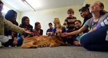 Seventh and eighth grade students pet and spend time with Lacey, a registered therapy dog, during a Career Café event at Ellicott Middle School in Ellicott, Colorado, Thursday, Oct. 22, 2015. Thea Wasche, 50th Force Support Squadron deputy commander and owner/handler of Lacey, spoke to the children about her work with the Red Cross and the benefits of therapy dogs. (U.S. Air Force photo/Staff Sgt. Debbie Lockhart)
