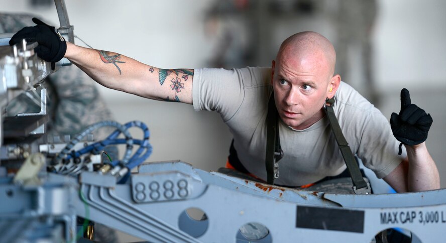 U.S. Air Force Staff Sgt. Gregory Nunley, 20th Aircraft Maintenance Squadron, 79th Aircraft Maintenance Unit, weapons load crew chief, signals a weapon loader operator during a weapons load crew of the quarter competition at Shaw Air Force Base, S.C., Oct. 16, 2015. In order to accurately place the munition onto the weapon loader arms, Nunley gave precise direction to ensure correct loading procedures. (U.S. Air Force photo by Senior Airman Jensen Stidham/Released)