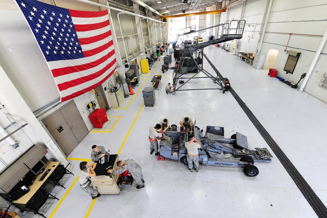 Airmen assigned to the aerospace ground equipment (AGE) shop perform maintenance on a bomb lift at Whiteman Air Force Base, Mo., Oct. 21, 2015. The mission of the AGE shop is to maintain and provide equipment for aircraft support with efficient and timely service. (U.S. Air Force photo by Senior Airman Keenan Berry/Released) 