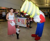 Energy Man, the energy awareness mascot, interacts with customers Oct. 21, 2015, at Andersen Air Force Base, Guam. Airmen with the 36th Civil Engineer Squadron informed Base Exchange patrons about the importance of energy conservation after the recent power incident that affected Guam's power grid. (U.S. Air Force photo by Airman 1st Class Arielle Vasquez/Released)