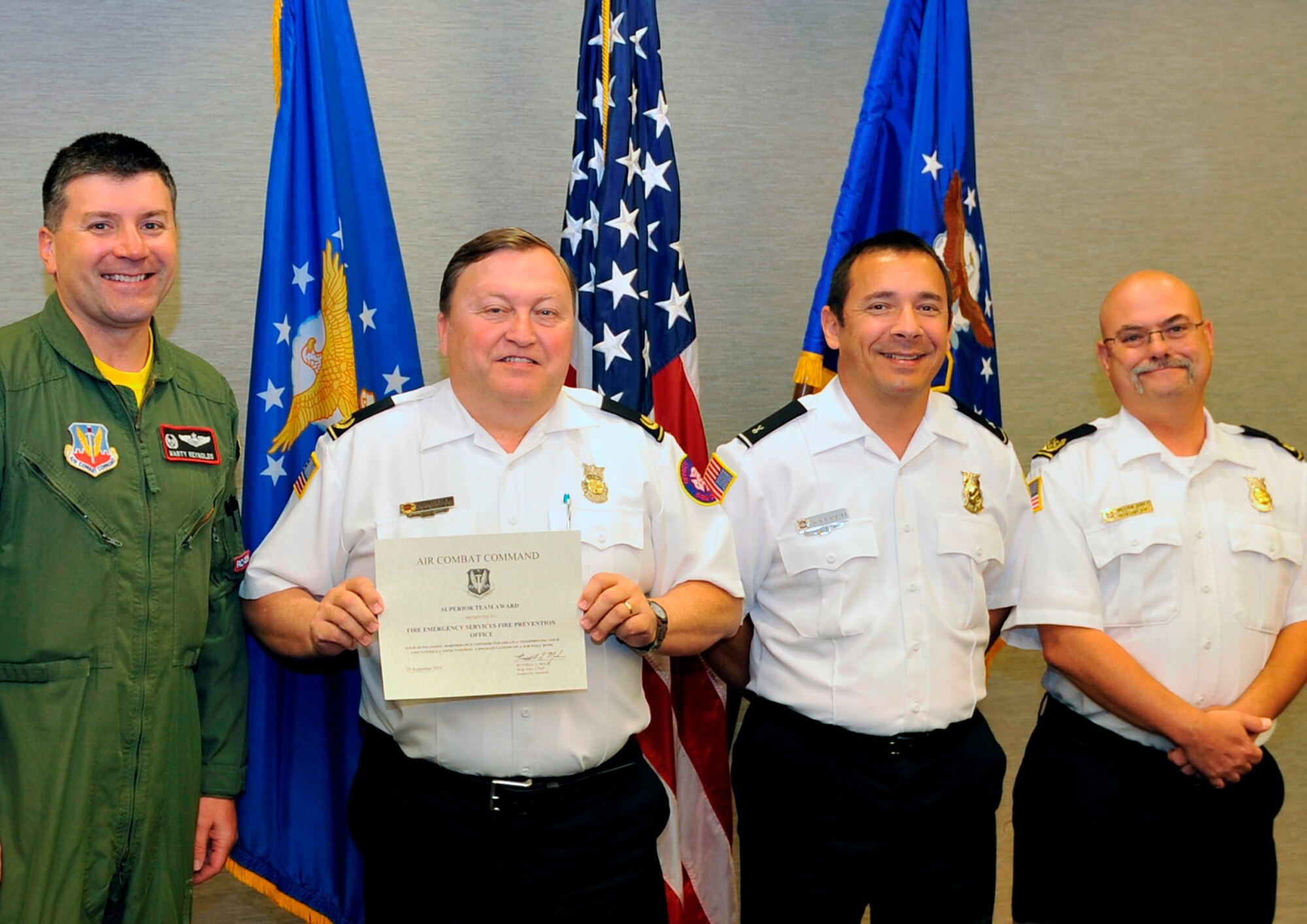 From left to right, Col. Marty Reynolds, 55th Wing commander, presents David Eblin, 55th Civil Engineer Squadron Fire Department chief,  David Andrews, 55th CES FD fire inspector and William Dudek, 55th CES FD fire prevention assistant chief,  with the Team Superior Performer Award Sept. 25, 2015. The team was given the award by the Inspector General following the most recent Unit Effectiveness Inspection. (U.S. Air Force photo by Jeff Gates/Released)