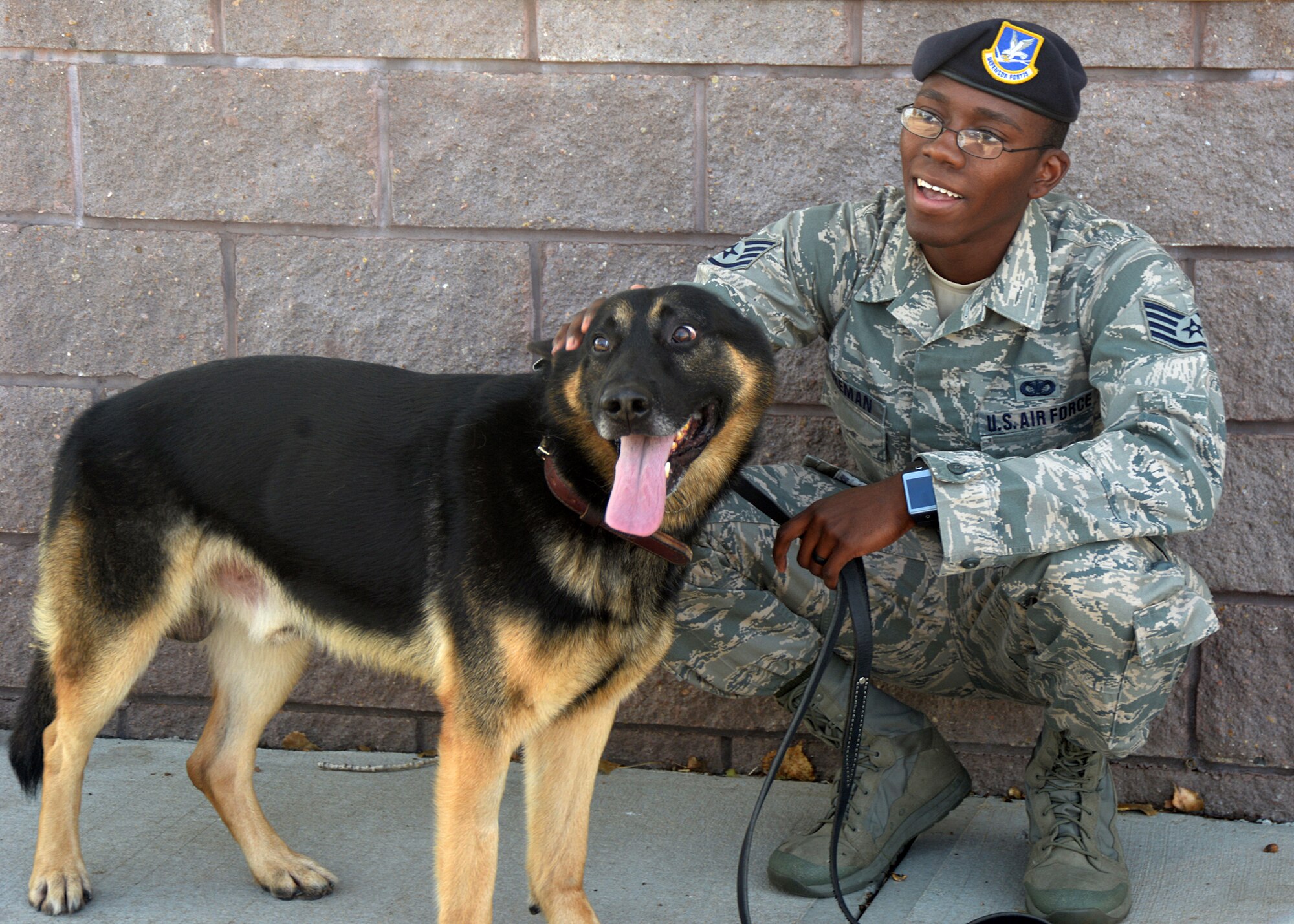 Staff Sgt. Elbert Foreman, 55th Security Force Squadron Military Working Dog handler, crouches beside Military Working Dog Rocky Oct. 21 at the 55th SFS MWD training facility. MWD Rocky was relocated to Offutt for training after he was unable to meet training requirements at Joint Base San Antonio, Texas. (U.S. Air Force photo by Kendra Williams/Released)