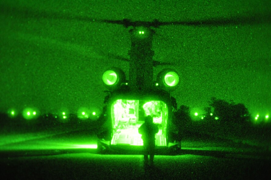 Airmen from the 60th Aerial Port Squadron and the Army National Guard's 49th Police Brigade practice loading and sling loading vehicles on a CH-47 Chinook cargo helicopter Oct. 14, 2015, at Travis Air Force Base, California. The units also practiced night time operations in total darkness with the aid of night vision goggles. (U.S. Air Force photo by Staff Sgt. Leah Johnson)