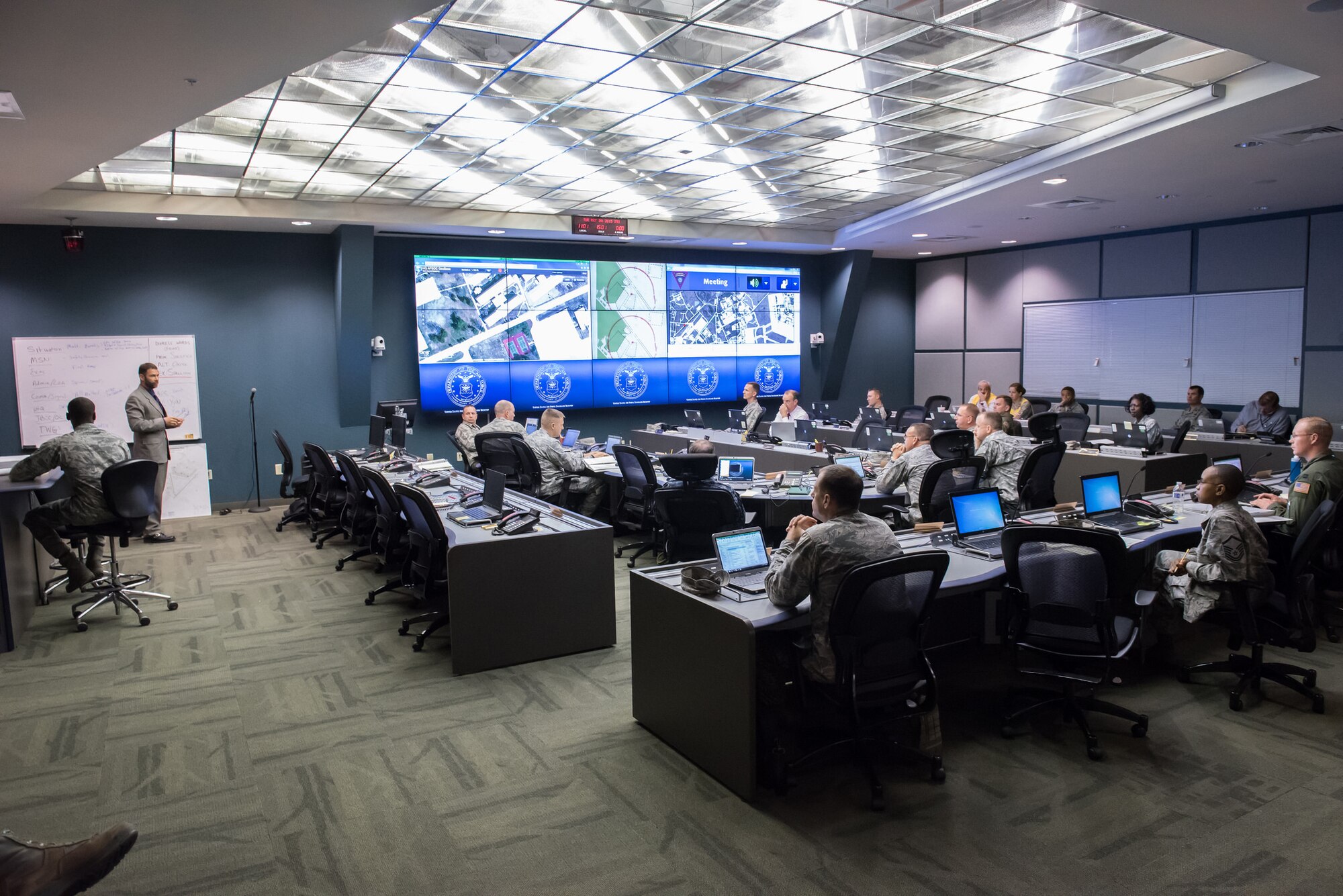 Emergency Operations Center personnel receive a briefing from Michael Stefani, 87th Air Base Wing Plans and Programs chief, during a joint, multi-platform training exercise at JB MDL, N.J., Oct. 20, 2015. The EOC is a central location where mission-essential leaders from different units meet to coordinate emergency response operations. (U.S. Air Force by Russell Meseroll/Released)