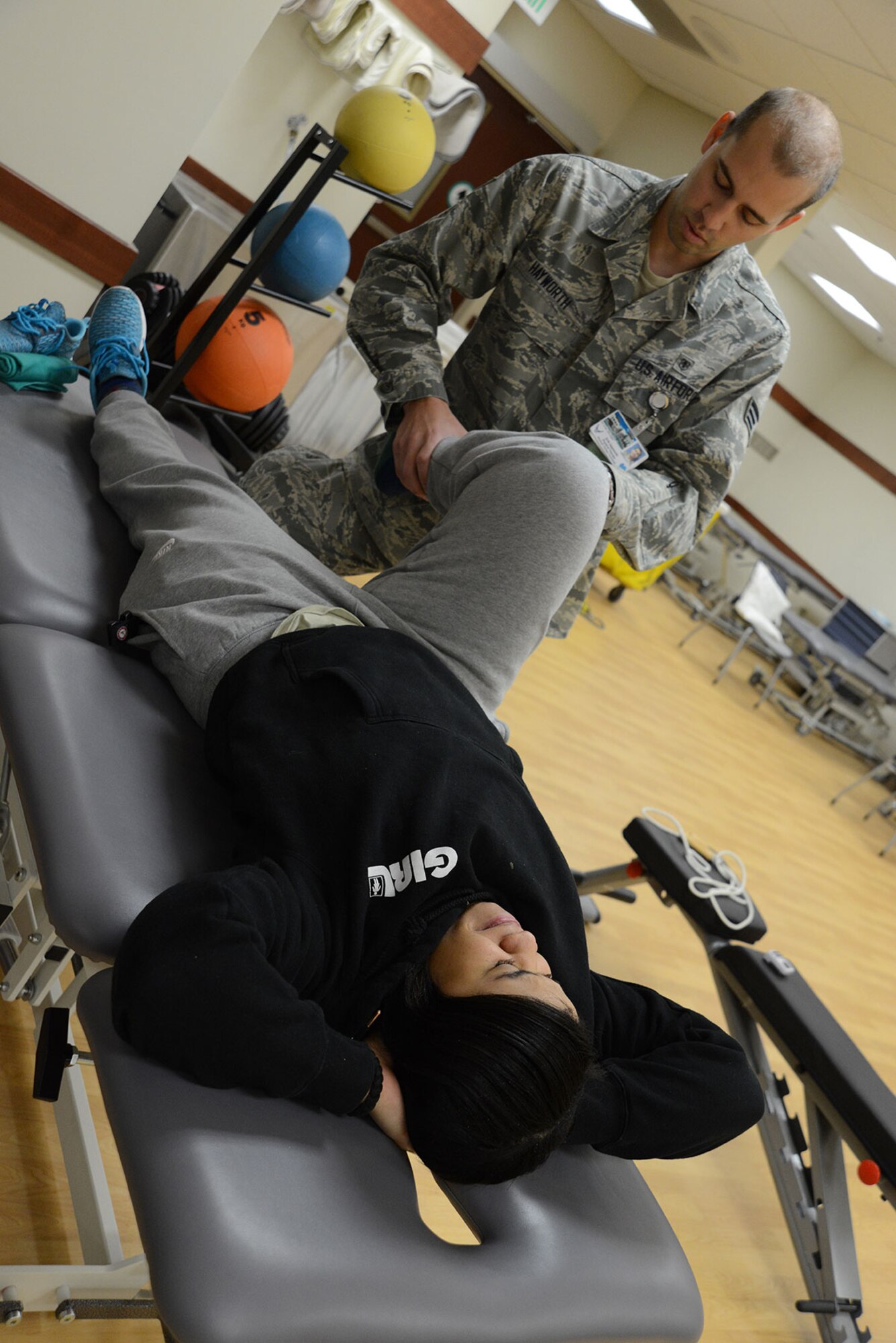 Senior Airman Erik Hayworth, 673d Medical Operations Squadron physical medicine technician, assists Staff Sgt. Constance Vaughn, 773d Civil Engineer Squadron Operations Management, with several stretches to help her acute knee injury at the physical therapy clinic on Joint Base Elmendorf-Richardson, Alaska, Oct. 14, 2015. The acute care program is opening its doors to all beneficiaries Nov. 6, 2015. The program, part of the physical therapy clinic, responds to acute injuries for quicker treatment. An acute injury is one that isn’t an emergency, but stems from a specific trauma to the bone, joint or muscle and can be seen at the acute care clinic at the JBER hospital. (U.S. Air Force photo/Airman 1st Class Christopher R. Morales)