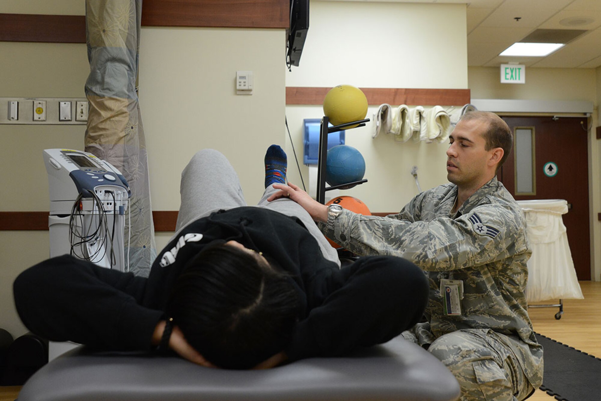 Senior Airman Erik Hayworth, 673d Medical Operations Squadron physical medicine technician, assists Staff Sgt. Constance Vaughn, 773d Civil Engineer Squadron Operations Management, with several stretches to help her acute knee injury at the physical therapy clinic on Joint Base Elmendorf-Richardson, Alaska, Oct. 14, 2015. The acute care program is opening its doors to all beneficiaries Nov. 6, 2015. The program, part of the physical therapy clinic, responds to acute injuries for quicker treatment. An acute injury is one that isn’t an emergency, but stems from a specific trauma to the bone, joint or muscle and can be seen at the acute care clinic at the JBER hospital. (U.S. Air Force photo/Airman 1st Class Christopher R. Morales)