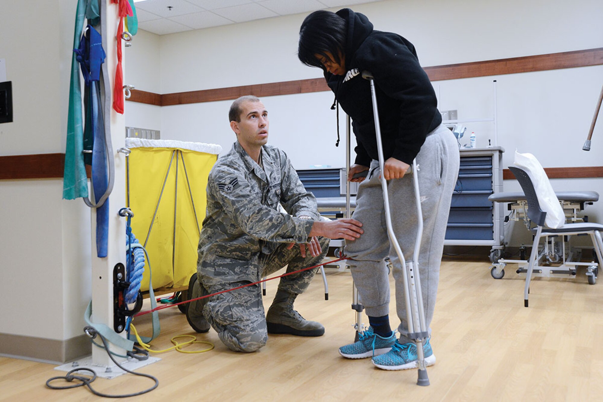 Staff Sgt. Constance Vaughn, 773d Civil Engineer Squadron Operations Management, uses a rubber band to work out her acute knee injury in a controlled and healthy manner with the guidance of Senior Airman Erik Hayworth, 673d Medical Operations Squadron physical medicine technician, at the physical therapy clinic on Joint Base Elmendorf-Richardson Oct. 14. The acute care program is opening its arms to all beneficiaries Nov. 6. The program, part of the physical therapy clinic, responds to acute injuries for quicker treatment. Treatment to acute injuries starts with reducing pain, increasing mobility then regaining strength. (U.S. Air Force photo/Airman 1st Class Christopher R. Morales)
