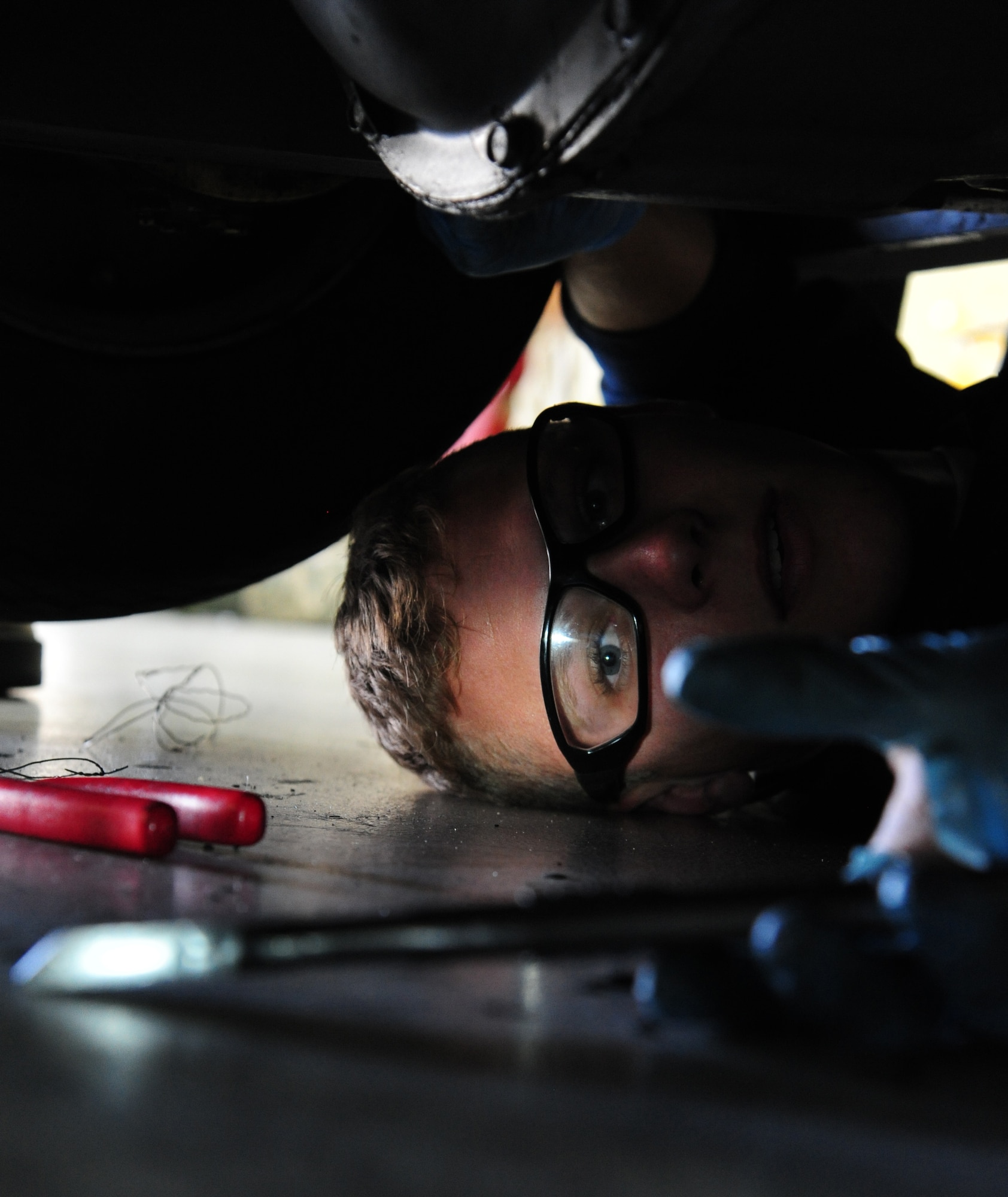 Airman 1st Class Austin Elrod, 509th Maintenance Squadron aerospace ground equipment journeyman, reaches for a ratchet to perform maintenance on a bomb lift at Whiteman Air Force Base, Mo., Oct. 21, 2015. Bomb lifts are used to transport bombs from storage sites to the aircraft. (U.S. Air Force photo by Senior Airman Keenan Berry/Released)