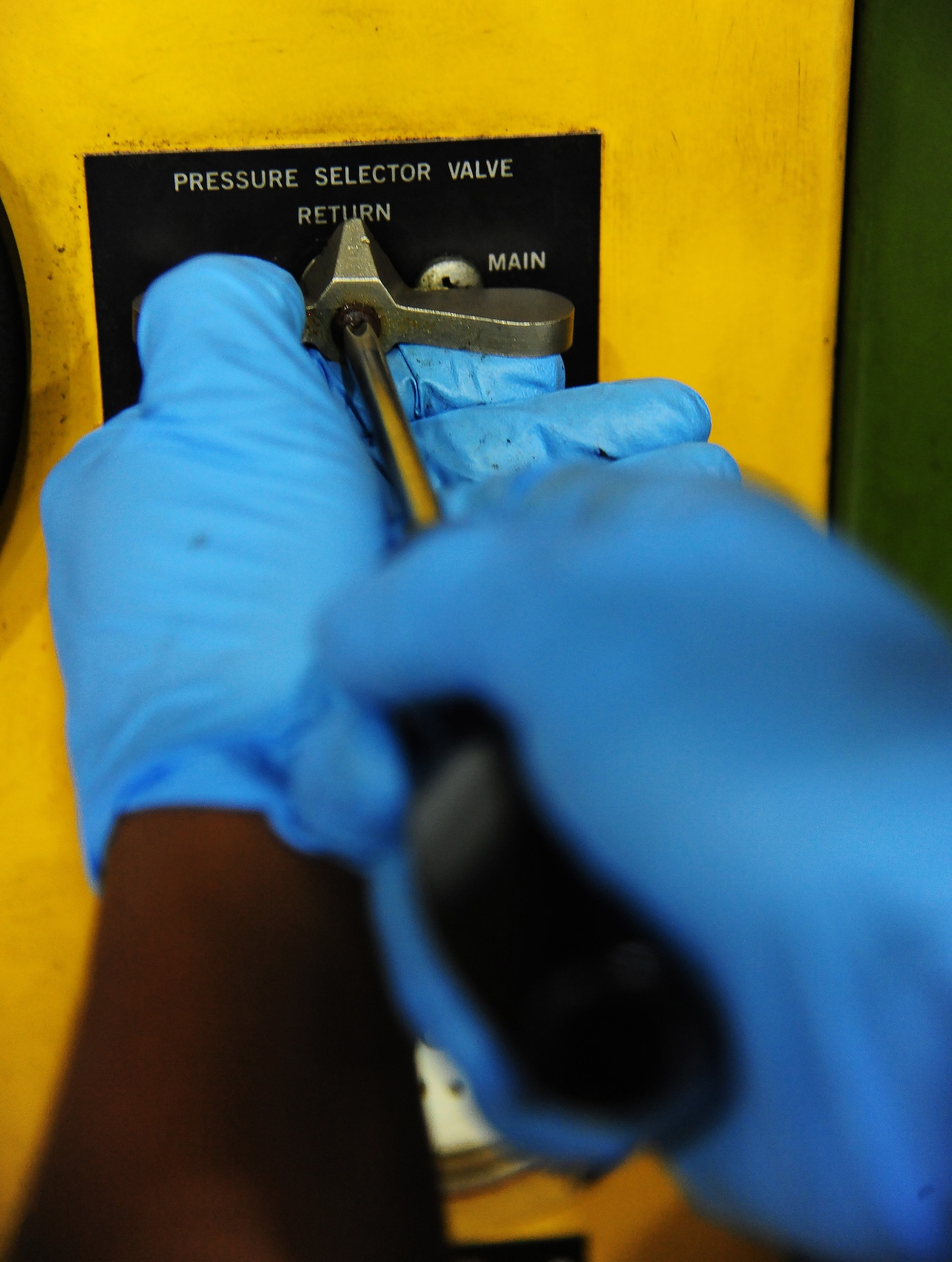 Airman 1st Class Adrian Quichocho, 509th Maintenance Squadron aerospace ground equipment journeyman, tightens a valve on a hydraulic test stand at Whiteman Air Force Base, Mo., Oct. 21, 2015. The stand is used to locate aircraft to hangers for when maintenance is performed. (U.S. Air Force photo by Senior Airman Keenan Berry/Released)