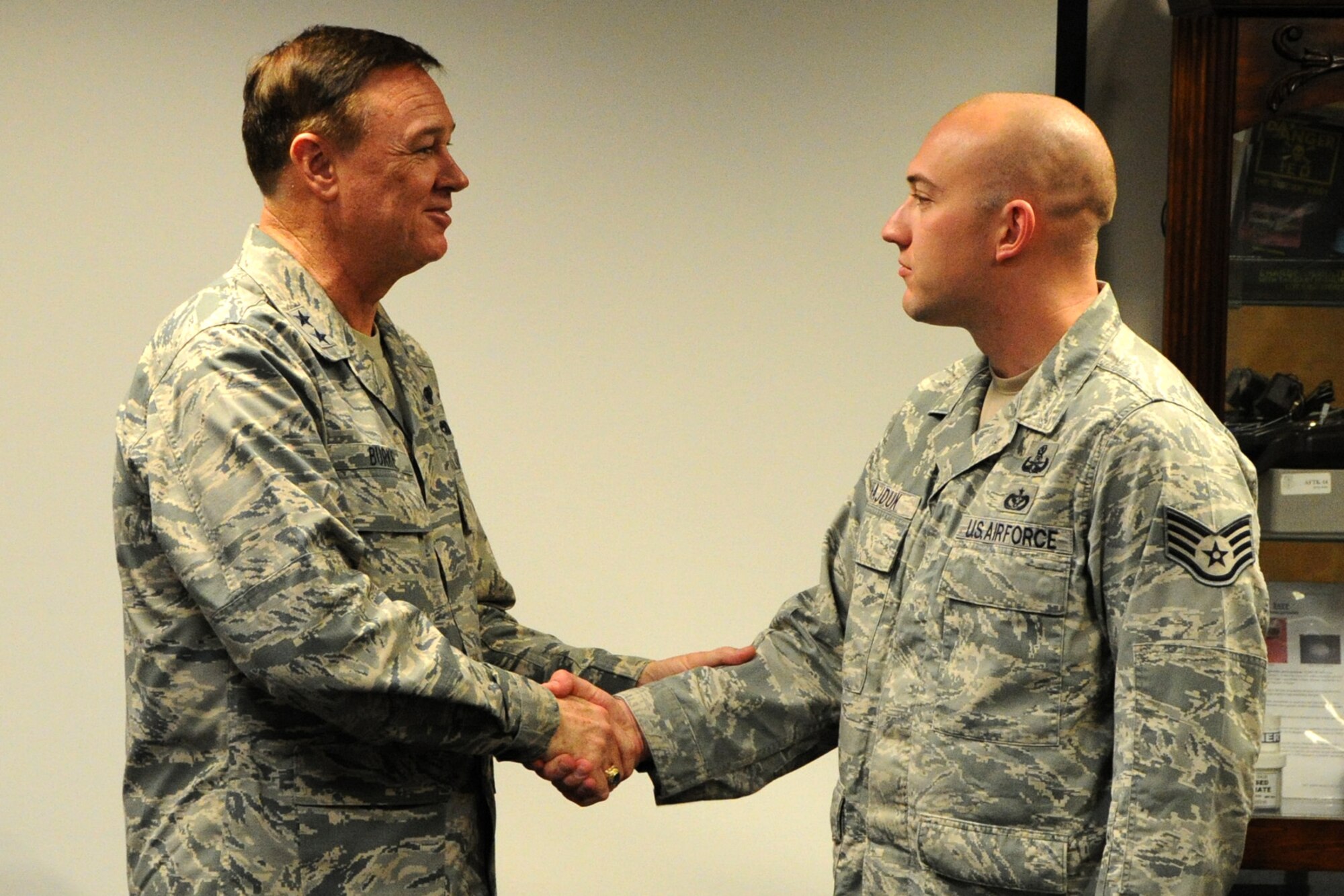 Air Force District of Washington Commander Maj. Gen. Darryl W. Burke coins SSgt Mark Hadjuk, 11th Civil Engineer Squadron Explosive Ordnance Disposal craftsman, on Joint Base Andrews, Md., Oct. 23, 2015. Burke communicates his appreciation for the EOD Airmen’s sacrifice for the mission and recognized excellence within their career field. (U.S. Air Force photo/Staff Sgt. Matt Davis)