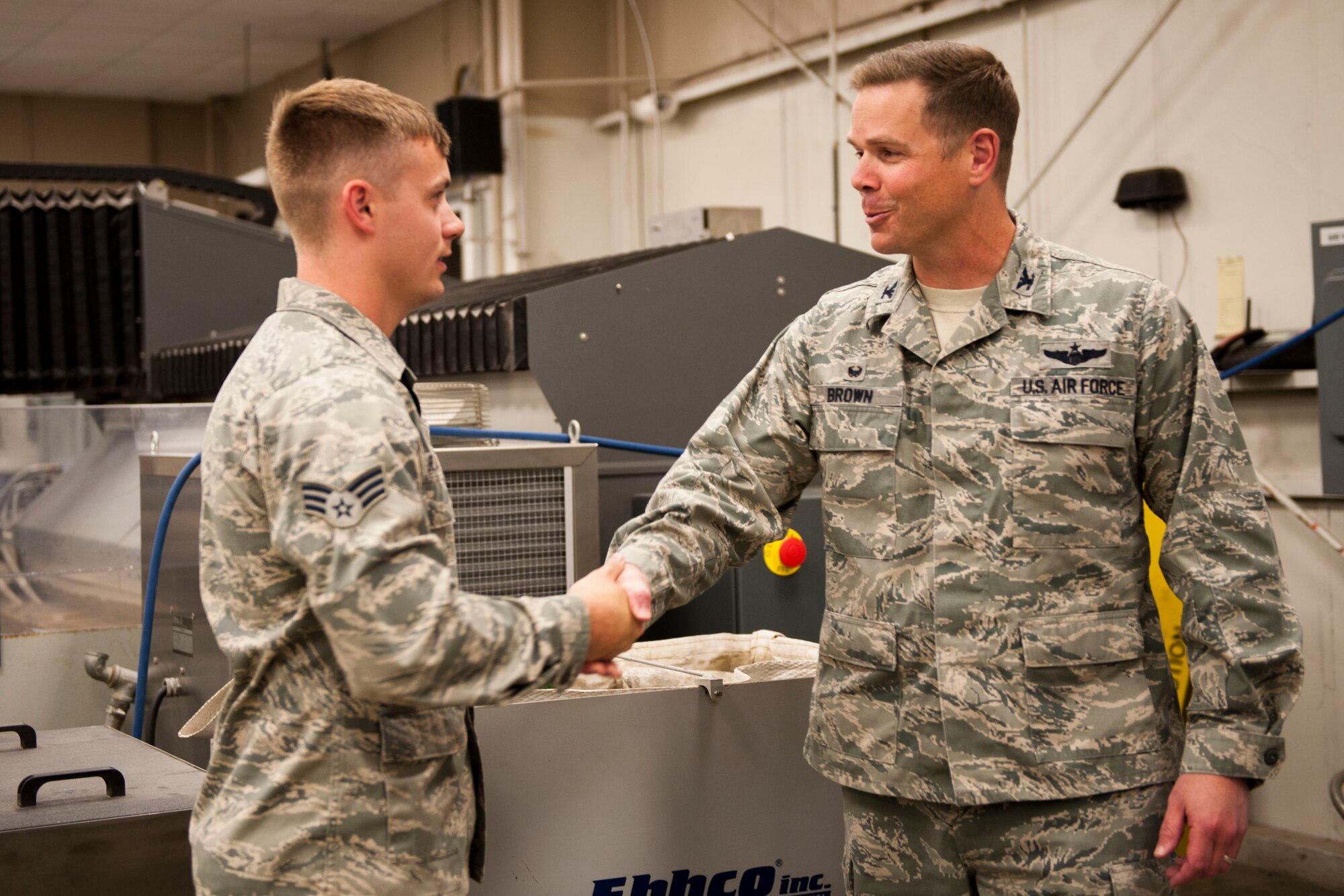 U.S. Air Force Col. Charles Brown Jr., 19th Airlift Wing commander, congratulates U.S. Air Force Senior Airman Dustin Blakney, a 19th Maintenance Squadron aircraft metals technology journeyman, as Combat Airlifter of the Week Oct. 19, 2015, on Little Rock Air Force Base, Ark. Blakney facilitated a Bio-Environmental survey for meal working on beryllium structors, allowing accurate monitoring of a hazardous metal. (U.S. Air Force photo by Senior Airman Stephanie Serrano)