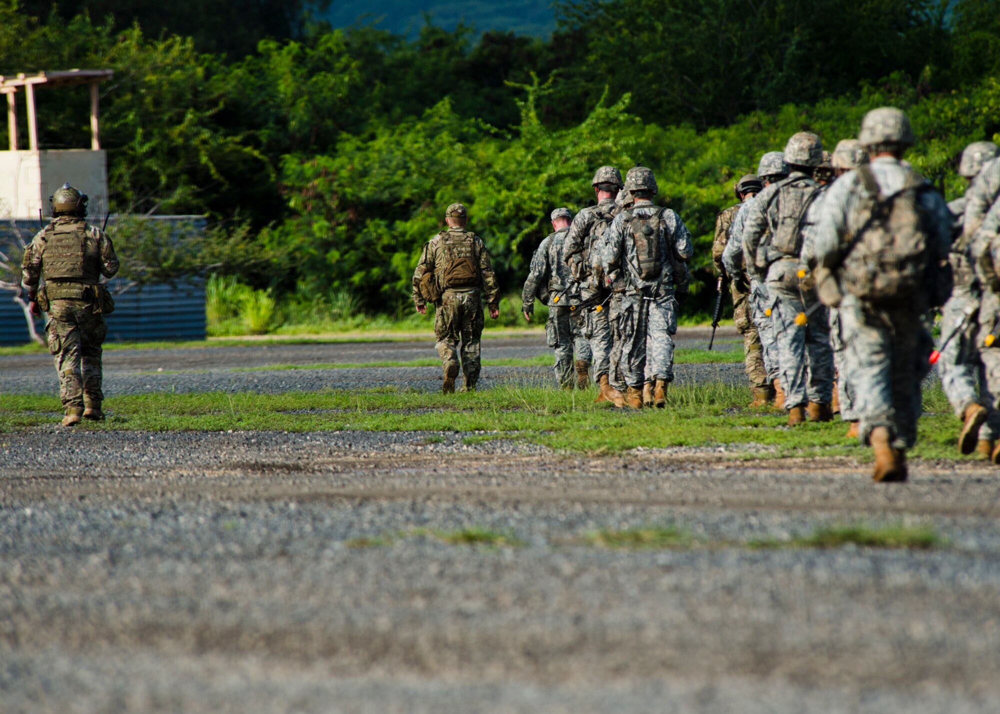 Airmen from the 25th Air Support Operations Squadron and Soldiers from the 25th Infantry Division move from their simulated base during a field training exercise on Bellows Air Force Station, Hawaii, Oct. 21, 2015. During the three day FTX, Airmen and Soldiers trained together to sharpen their specific skillsets. The Airmen from the 25th ASOS focused on their ability to communicate with Army ground commanders to call in air support from a variety of air to ground assets. The FTX allows military members to deploy to field locations to conduct tactical operations under simulated combat conditions.(U.S. Air Force photo by Tech. Sgt. Aaron Oelrich/Released)