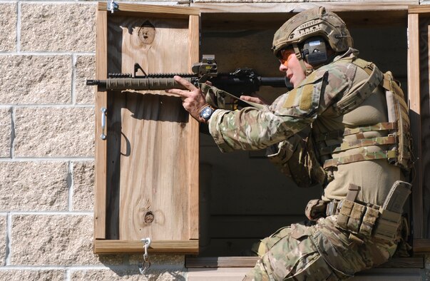 A Green Beret assigned to the 7th Special Forces Group (Airborne) engages a target from the window of a building during a stress shoot competition held Oct. 15 at Eglin Air Force Base, Fla. The competition tested the Special Forces Soldier's ability to navigate terrain and obstacles while engaging targets accurately despite his elevated heart rate and rapid breathing.  (Photo by Staff Sgt. William Waller)