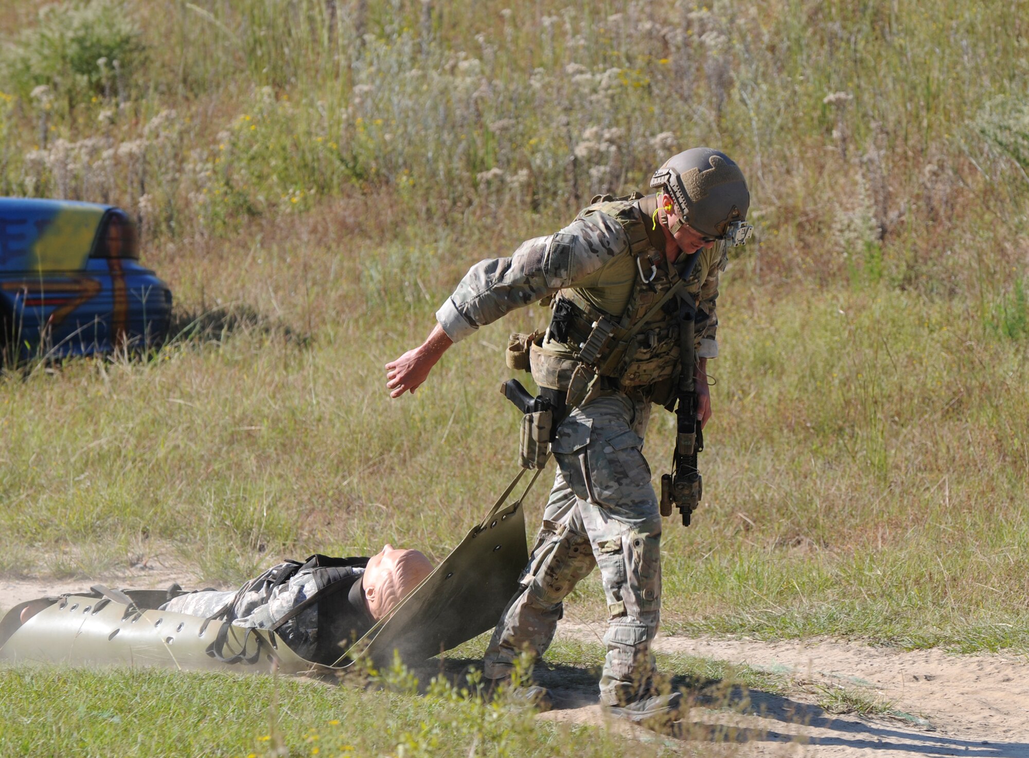 A Green Beret assigned to the 7th Special Forces Group (Airborne) drags a litter bearing a mannequin weighing 210 pounds to the finish line of a stress shoot competition held Oct. 15 at Eglin Air Force Base, Fla. The competition tested the Special Forces Soldier's ability to navigate terrain and obstacles while engaging targets accurately despite his elevated heart rate and rapid breathing.  (Photo by Staff Sgt. William Waller)