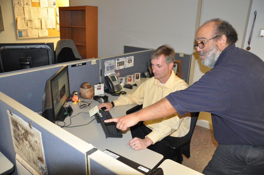 Jamie Rowe (left) and David Swanson, both information technology management specialists with the Active Directory team, review cases the team is working to resolve. Active Directory is responsible for solving the most complicated computer issues on base (U.S. Air Force photo / Brian Brackens)