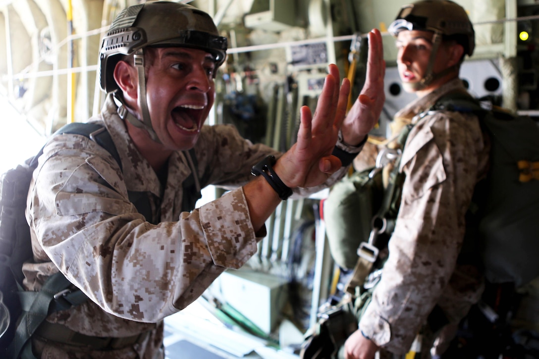 Marine Corps Gunnery Sgt. Gabriel Machado notifies a jump team of the estimated time of departure during static-line parachute operations and free fall jump training on Marine Corps Base Camp Pendleton, Calif., Oct. 16, 2015. 1st Recon conducted parachute operations in preparation for future deployments. Machado is an airborne and air delivery specialist with 1st Reconnaissance Battalion, 1st Marine Division. U.S. Marine Corps photo by Cpl. Demetrius Morgan