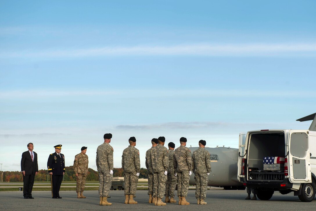 Defense Secretary Ash Carter and Army Chief of Staff  Gen. Mark A. Milley stand at attention as an Army carry team moves the transfer case of U.S. Army Master Sgt. Joshua L. Wheeler during the dignified transfer of his remains at Dover Air Force Base, Del., Oct. 24, 2015. Secretary Carter attended the ceremony to pay his respects to the fallen soldier. DoD photo by Air Force Senior Master Sgt. Adrian Cadiz 